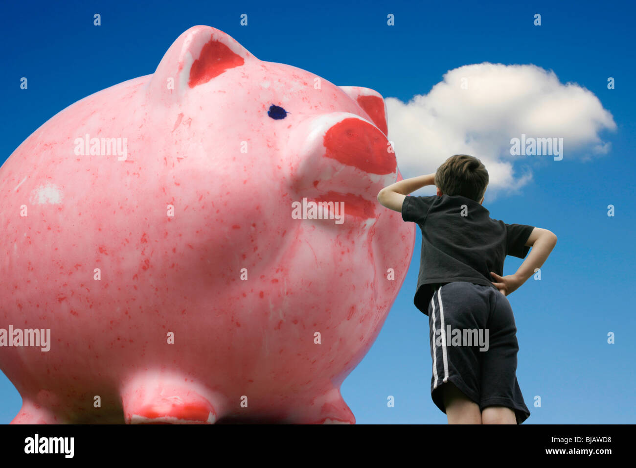 a-boy-looks-up-at-his-giant-grown-piggy-bank-BJAWD8.jpg